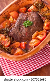 Pot Roast With Tomatoes, Herbs And A Portion Of Browned Braised Beef In A Terracotta Casserole Dish Simmered In A Rich Gravy Or Sauce