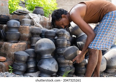 Pot Seller Arranging Handmade Pots To Sell During Summer Heat Wave In Market - Concept Of Indian Small Road Side Businesses.