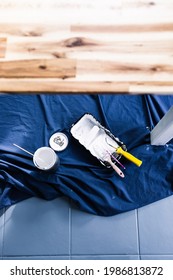 Pot Of White Paint With Paint Tray Roller And Brushes On Top Of Blue Drop Sheet Ready To Paint A Table, Shot At Shallow Depth Of Field With Paint Can Text Blurred