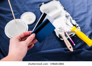 Pot Of White Paint With Paint Tray Roller And Brushes With Payment Card On Top Of Blue Drop Sheet Concept Of Costs Of DIY And Renovating, Shot At Shallow Depth Of Field With Paint Can Text Blurred