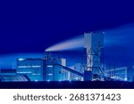 Potash mining and processing facility in Saskatchewan at night with illuminated structures and smoke under a dark sky.