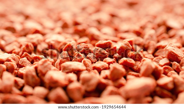 Potassium chloride is a red\
mineral fertilizer close-up. Red background of fertilizer potassium\
chloride. Texture of granular potassium chloride is red.\
Macro.