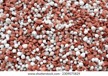Potassium chloride and superphosphate - close-up of red and white colored mineral fertilizer, top view. Red and white background of potassium chloride and superphosphate fertilizer, top view.