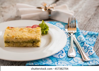 Potato Casserole With Spinach On A Plate And Cutlery.