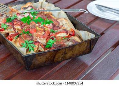 Potato, Chicken And Red Pepper Bake Garnished With Fresh Parsley In Baking Tray On Garden Table