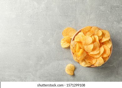 Potato chips. Beer snacks on grey background, space for text. Top view