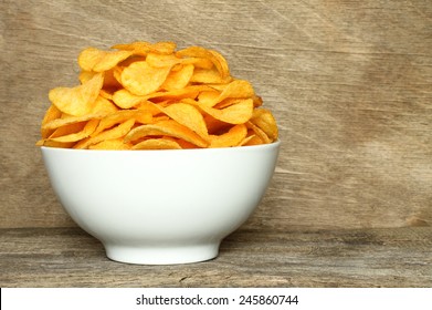 Potato chips bowl on a wooden background  