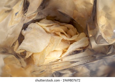 Potato Chips In A Bundle Close Up. Crispy Potato Chips To Eat From Bag As Snack With Calories And Cholesterol Crisp Closeup.