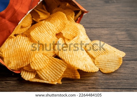 Potato chips, delicious BBQ seasoning spicy for crips, thin slice deep fried snack fast food in open bag.