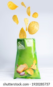 Potato Chips Falling Into A Pack Of Chips On A White Background