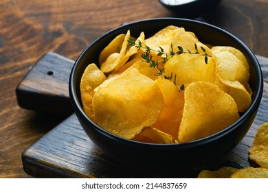 Potato Chips. Fast Food. Crispy Potato Chips Ceramic Black Bowl With Sour Cream Sauce And Onions In Wooden Stand On Old Kitchen Table Wooden Background. American Tradition. Hot BBQ. Top View.