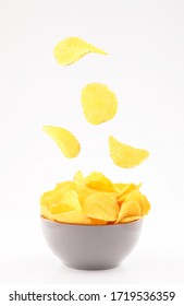 potato chips flying in gray bowl isolated on white background front view