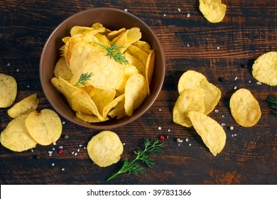 Potato chips with greens in a bowl, top view