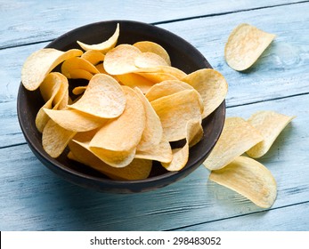 Potato chips on a blue wooden background. - Powered by Shutterstock