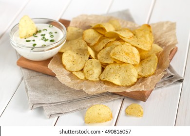 Potato chips on a parchment on a table. Concept of unhealthy food.