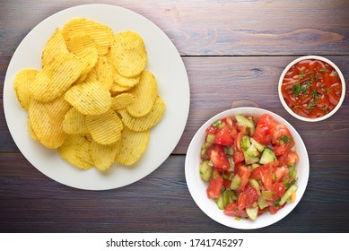 Potato Chips On A White  Plate With Vegetarion Salad. Chips On A Purple Wooden Background Top View.