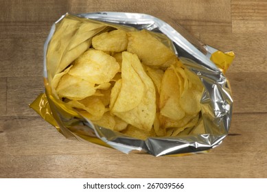 Potato Chips In An Open Bag On A Wooden Table