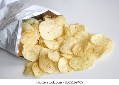 Potato Chips In Packet On White Table. Package Of Tasty Potato Chips Open With Food Out Of It On Table. Brandless Package For Logo. Layout Close Up Mockup