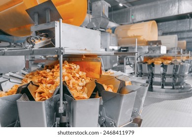 Potato chips production line at food plant. Filling machines for snacks. - Powered by Shutterstock