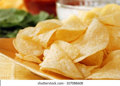 Potato Chips With Salsa, Fresh Veggies And Party Dip In Soft Focus In Background.  Macro With Shallow Dof.