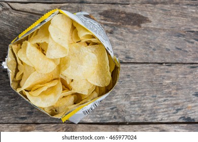 Potato Crisps In Bag On Wooden Table