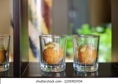 Potato Croquettes dessert in shot glasses on wood shelf