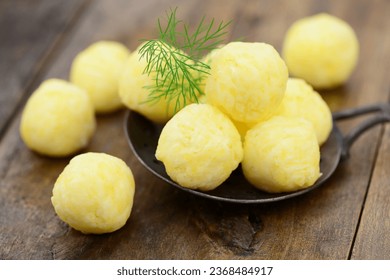 Potato dumplings with herbs on wooden  background, closeup.