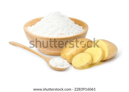 Potato flour in wooden bowl and spoon with raw potatoes with slices isolated on white background. 