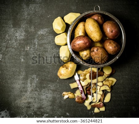 Potato food . The concept of wet potatoes in the colander on the stone table . Free space for text. Top view