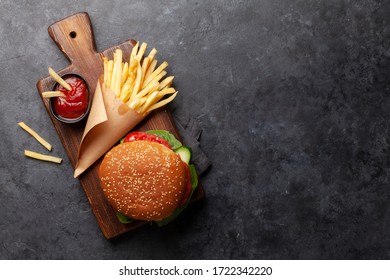 Potato fries chips with ketchup and hamburger. Fast food take away. Top view with copy space - Powered by Shutterstock