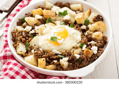 Potato Hash With Sausage And Fried Egg In A Baking Dish