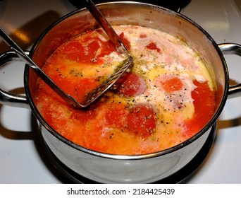 Potato Masher Mixing Tomatoes And Cream In Pot For Tomato Soup Or Sauce