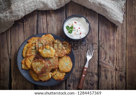 potato pancakes with sour cream on  wooden table