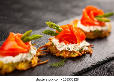 Potato pancakes topped with smoked salmon,asparagus and sour cream for holiday - Powered by Shutterstock