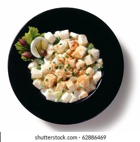 Potato Salad In A Black Bowl, Isolated On A White Background.