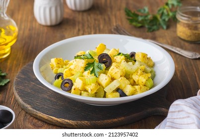 Potato Salad With Green Selery And Olives In A Gray Ceramic Bowl On A Wooden Background. Recipes For Potato Salads. Healthy Food, Vegan And Lean Recipes.