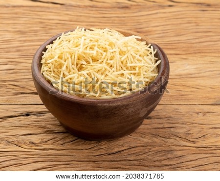 Potato straw or shoestring potato in a bowl over wooden table.