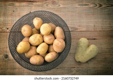 Kartoffelknollen in Korb auf Holztisch.