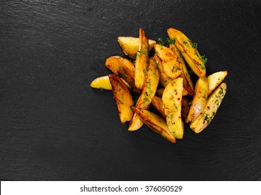 Potato wedges on black background. Top view.