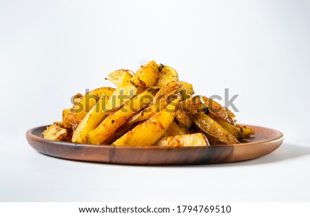 Potato wedges on wooden plate and white background. Front view. Stockfoto © 