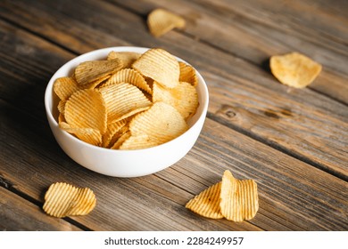 Potatoes chips in bowl good for snack for beer or ale on a natural wooden table. Good for beer festival, pub, restaurant advertising. - Powered by Shutterstock