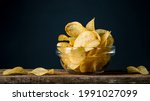 Potatoes Chips. Chips in glass bowl good for snack for beer or ale on natural wooden table. Good for beer festival, pub, restaurant advertising. Food and Drink photography. Macro high resolution Photo