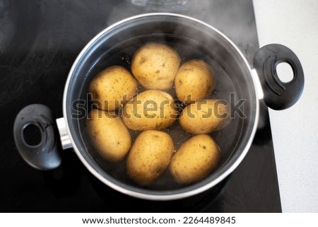Potatoes cooking in a pot with boiling water. Concept of preparing a recipe with boiled potatoes. 