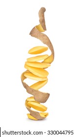 potatoes cut into pieces with the peel in a spiral in the air on an isolated white background