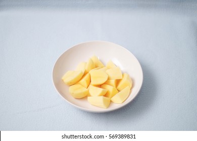 potatoes cut in white bowl on white background