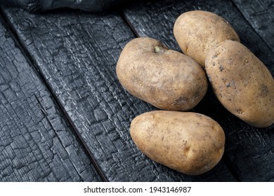 Potatoes On Burnt Black Wood