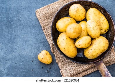 Potatoes top view on rustic dark background copy space.