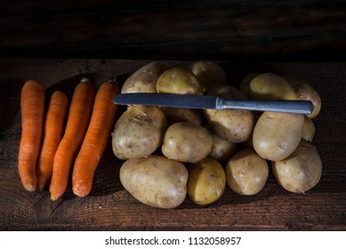 Potatos and vegetable on the rustic table with knife