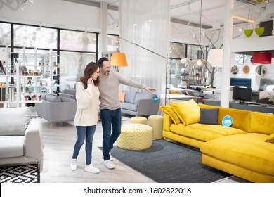 Potential Buyers. Two People Discussing Furniture Models In A Modern Furniture Shop