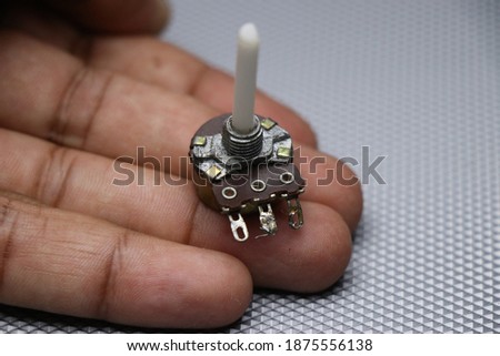 Potentiometer which is used in various electronic projects,radios and guitars for regulating resistance. Potentiometer held in hand